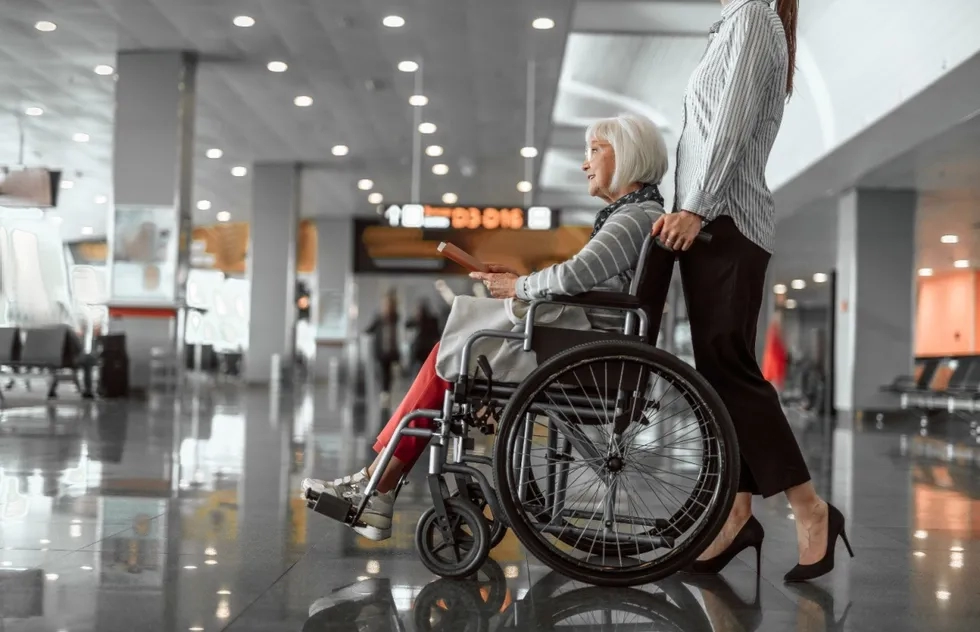 Woman in wheelchair pushed by escort