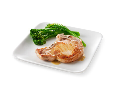 Brown Sugar Brined Pork Chops with brocollini on a white plate