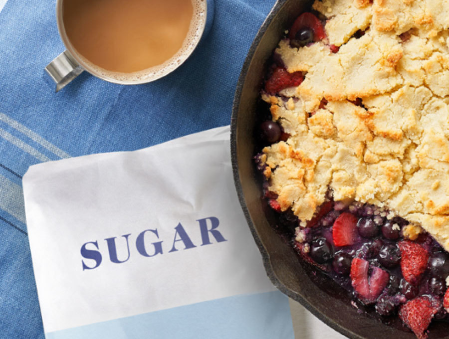Berry cobbler sitting next to a bag of traditional sugar