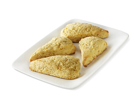 four ginger orange Scones on a white plate