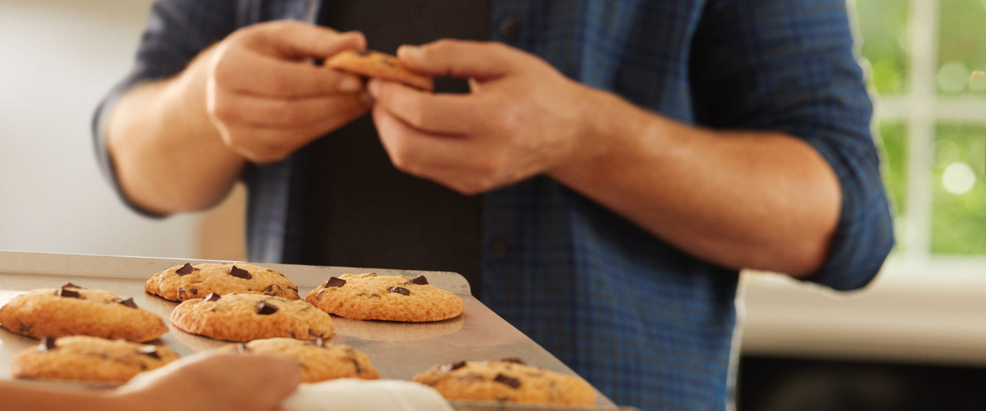 Hands holding a fresh-from-the-oven chocolate chip cookie