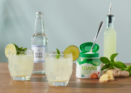 Ginger mojito mocktails sitting on a table with various ingredients and Truvia sweetener