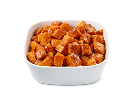 Bowl of golden browned candied yam cubes