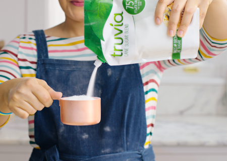 Woman pouring Truvia sweetener from a bag into a measuring cup