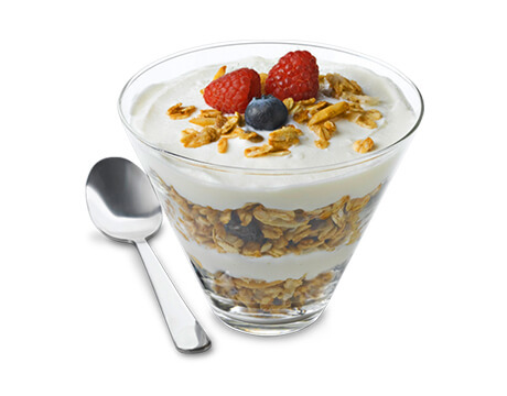 fruit and nut granola in a clear parfait glass