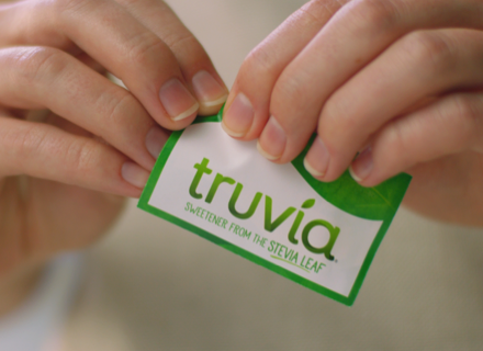 Hands opening a Truvia Sweetener Packet