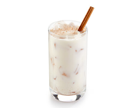 horchata in clear glass with cinnamon straw