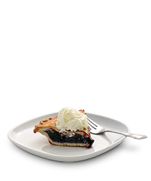 Slice of blueberry pie with a scoop of vanilla ice cream on a small white serving dish