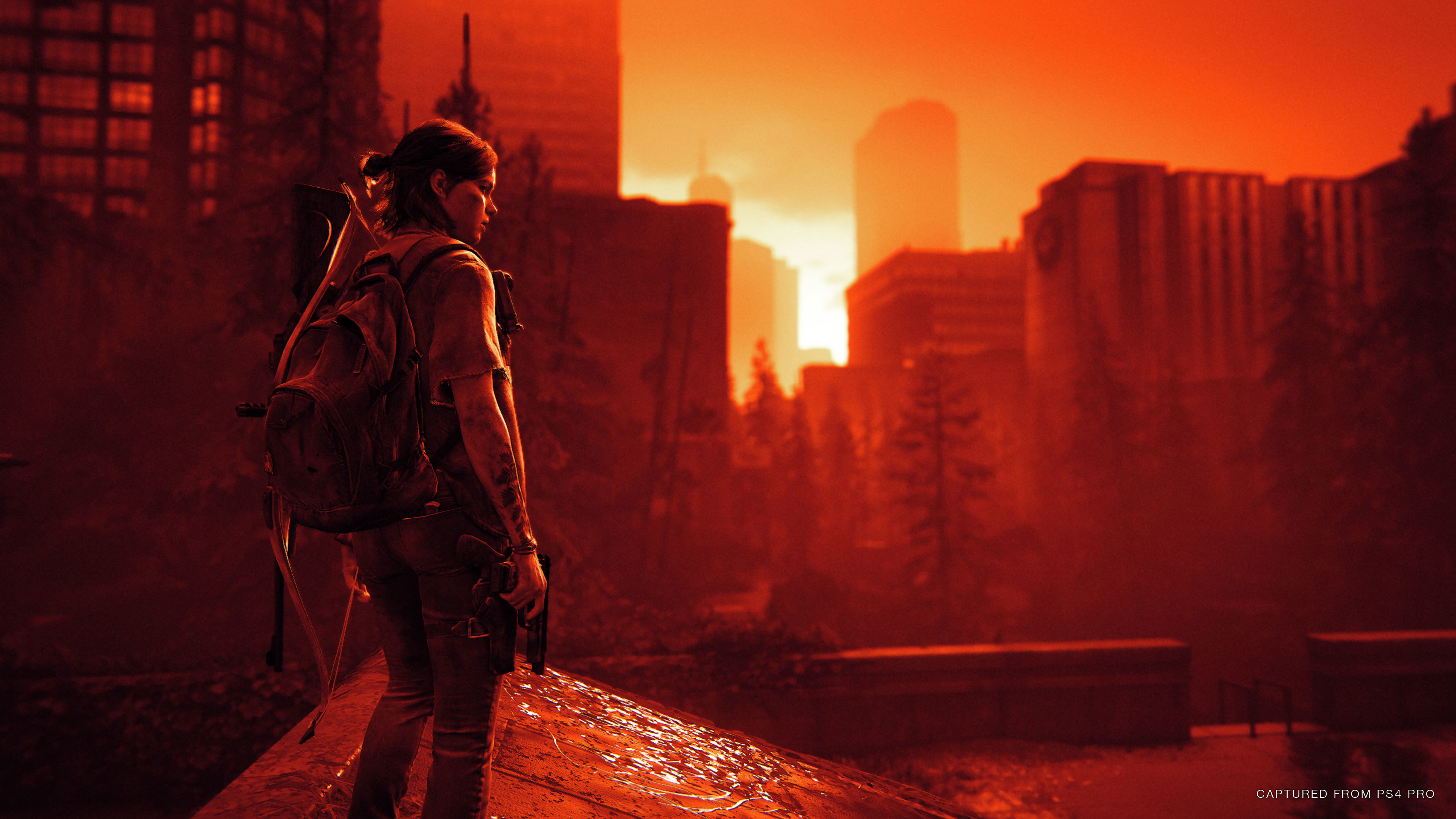 Ellie stands on a rooftop looking out to the hospital with the Inferno render mode over the image.