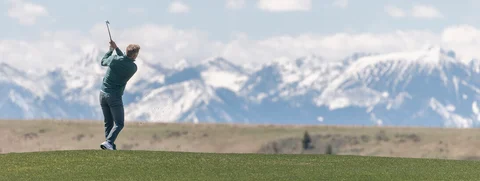Man on golf course looking out over mountains