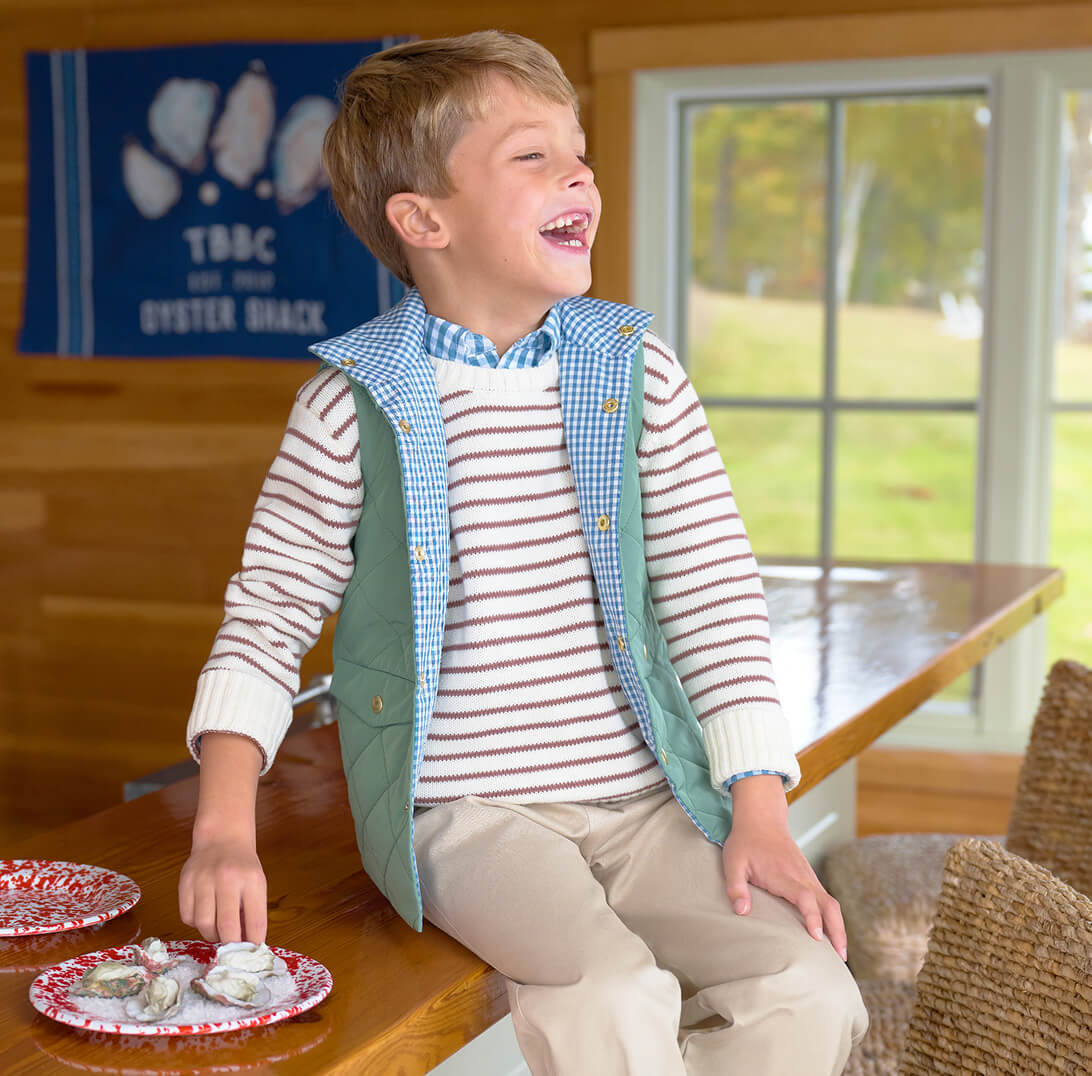 Young boy smiling sitting on a table