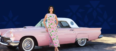 Women leaning up against a vintage pink car