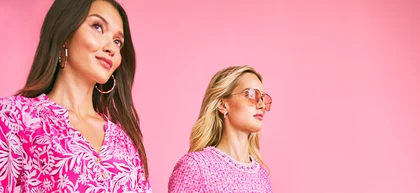 Women walking in front of pink backdrop