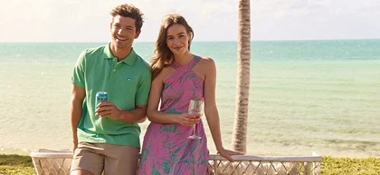 Man and women holding drinks on beach