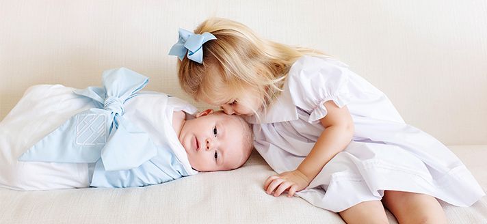 Young girl kissing babies head