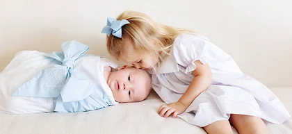 Young girl kissing babies head