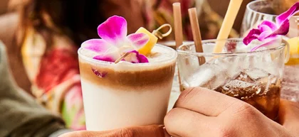 two people cheersing with drinks