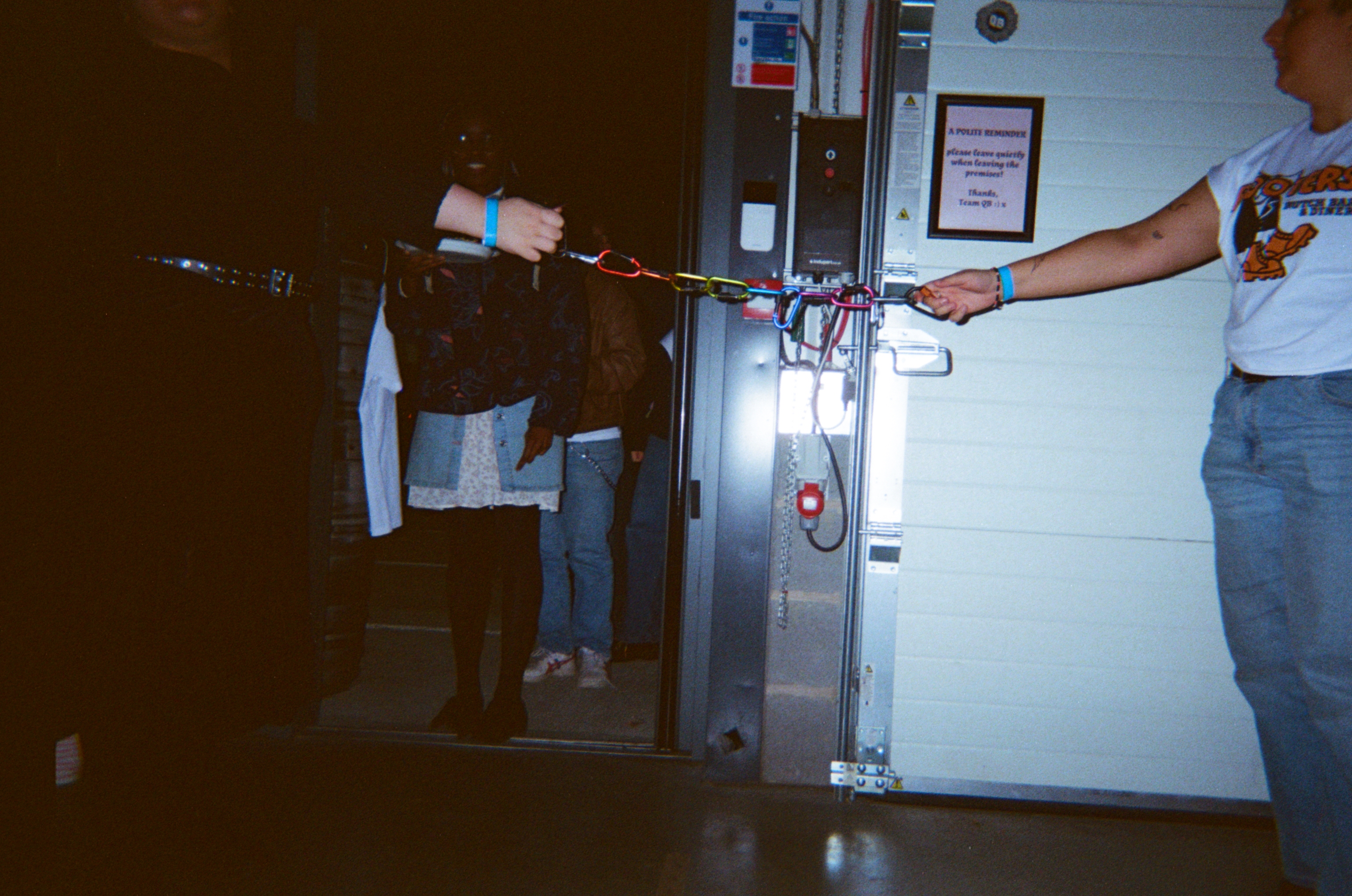 Two people holding a colourful rope or cord in what appears to be a ship's interior with metal walls and equipment.