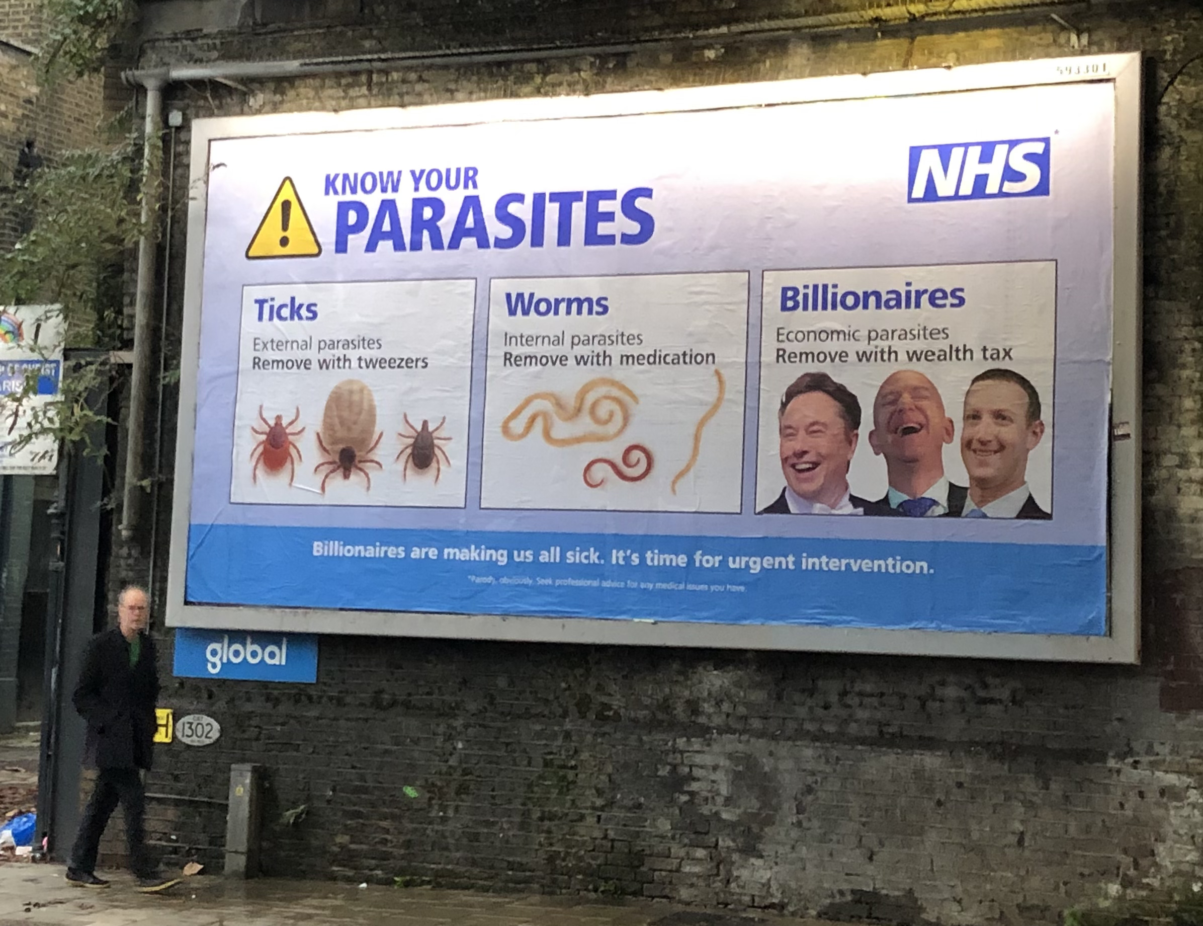 Street billboard with "Know Your Parasites" NHS spoof design showing ticks, worms, and "billionaires" with politician photos.