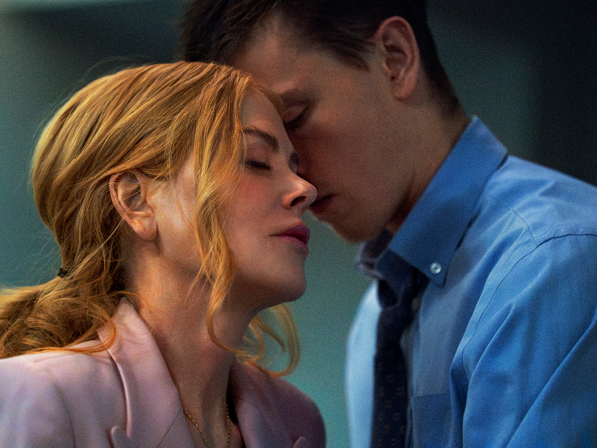 A close-up shot of a man and woman embracing, with the woman's eyes closed and the man's face close to hers.