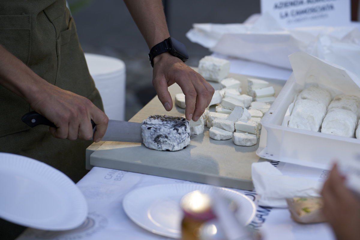 A chef cuts a soft goat's cheese on a table.