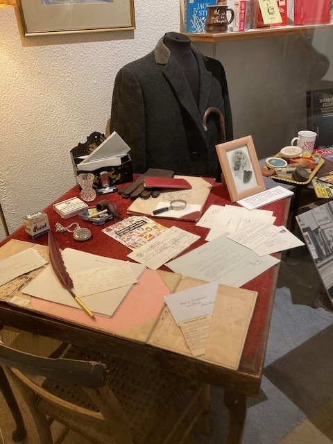 A desk displaying scattered documents, a framed photo, and a jacket.