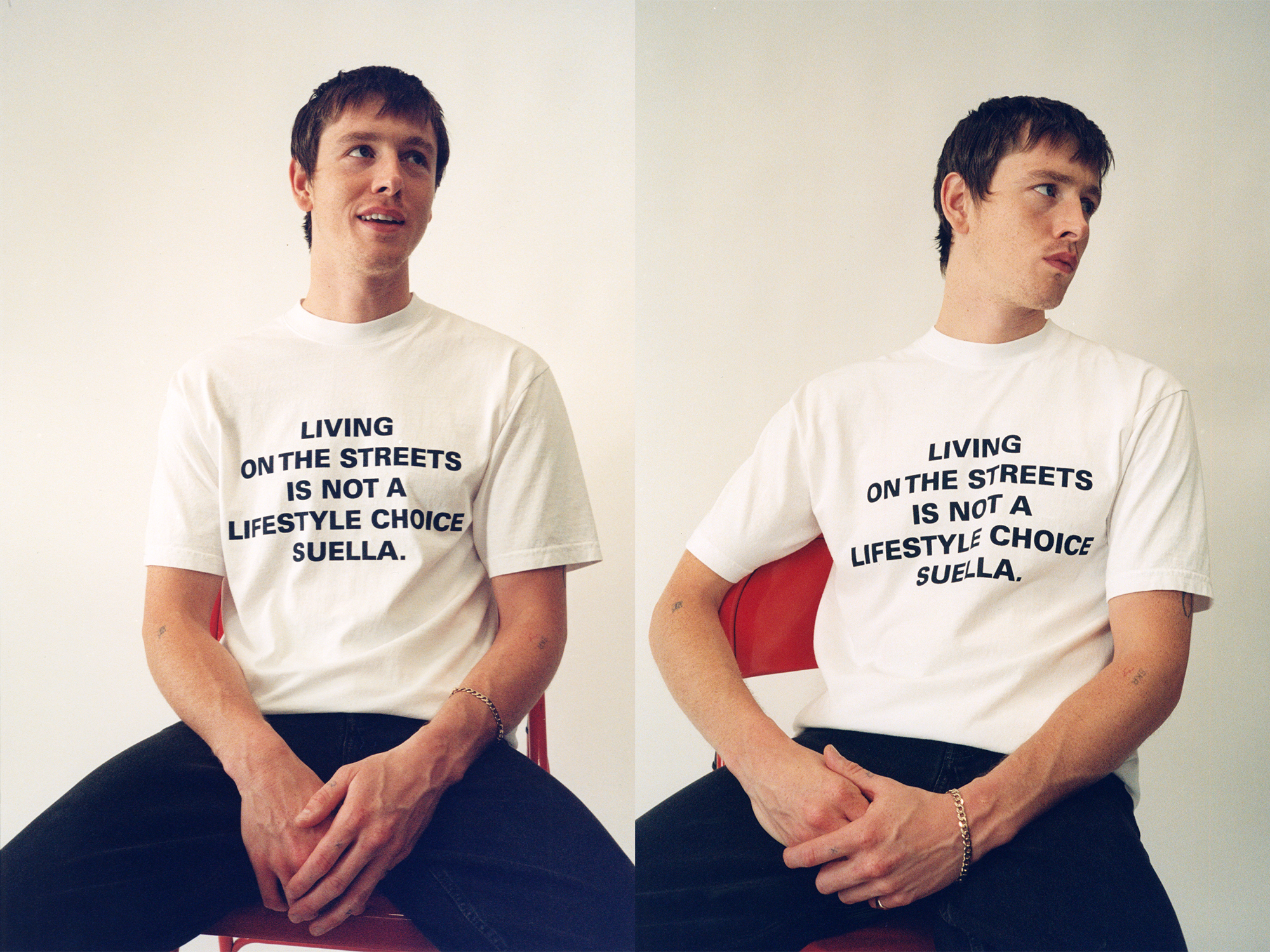 Two young men wearing identical white t-shirts with black text reading "LIVING ON THE STREETS IS NOT A LIFESTYLE CHOICE SUELLA."