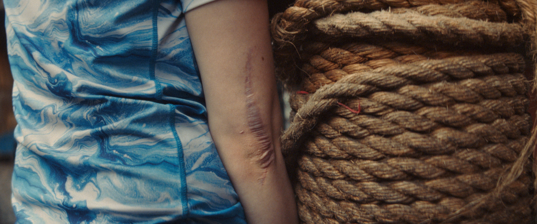 Crumpled blue fabric draped over braided rope.