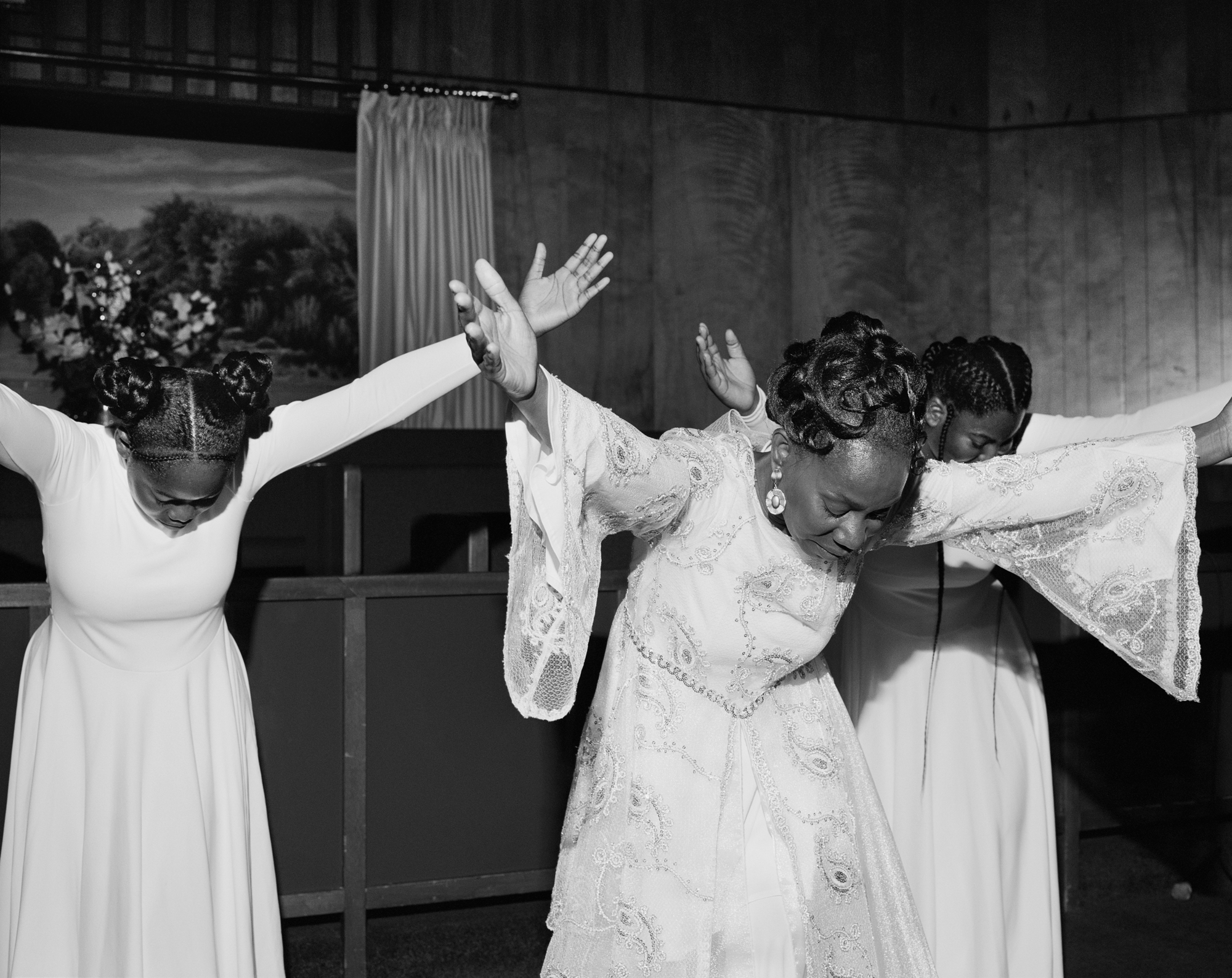 Celebratory dance by two women in traditional folk costumes, arms raised joyfully.