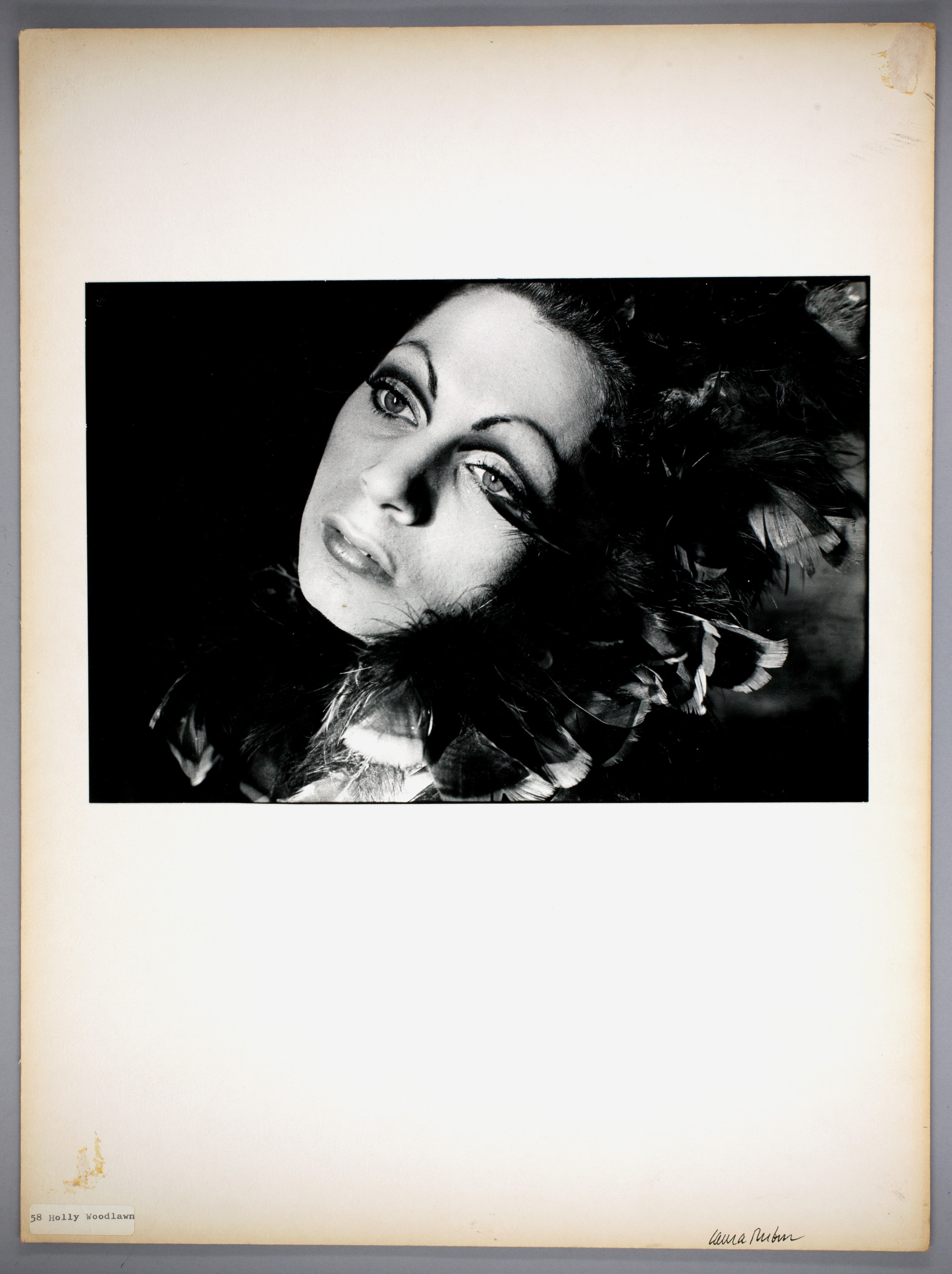 Black and white portrait of a woman with dark curled hair and intense gaze.