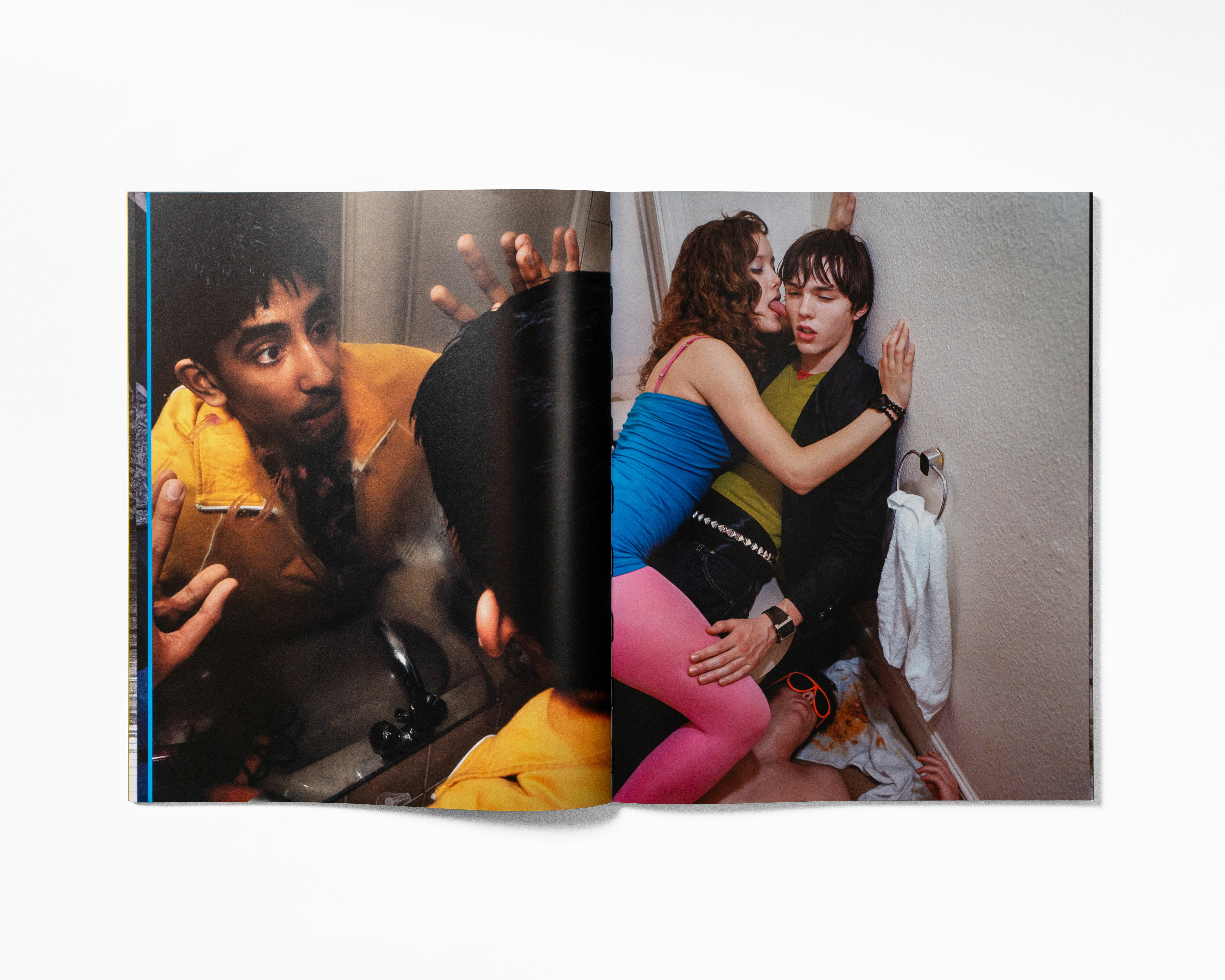 Two people in intimate embrace, wearing colourful outfits against a dark background.