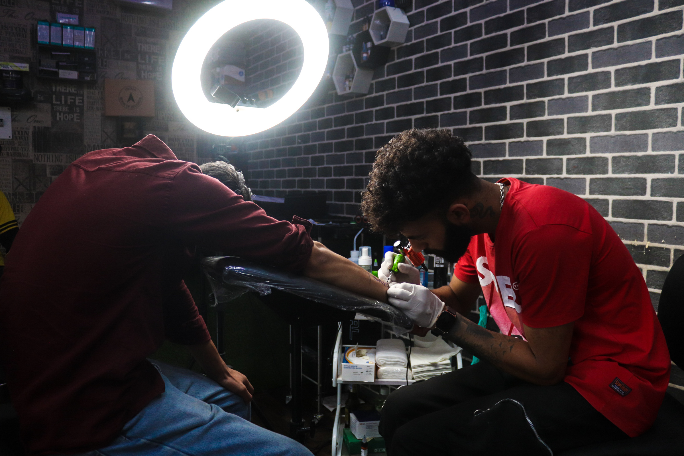 Neon-lit studio with two people in red shirts working on an unidentified task.