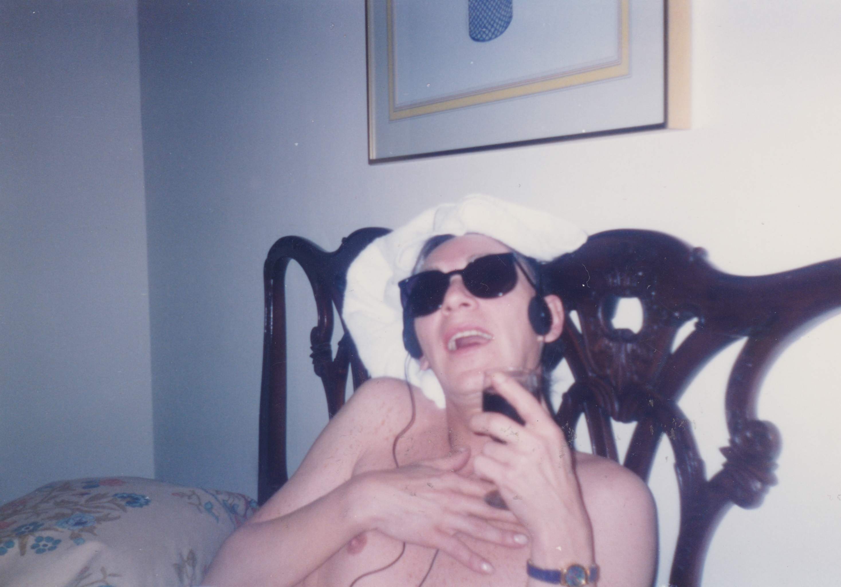 Seated person wearing sunglasses, relaxed pose on chair.