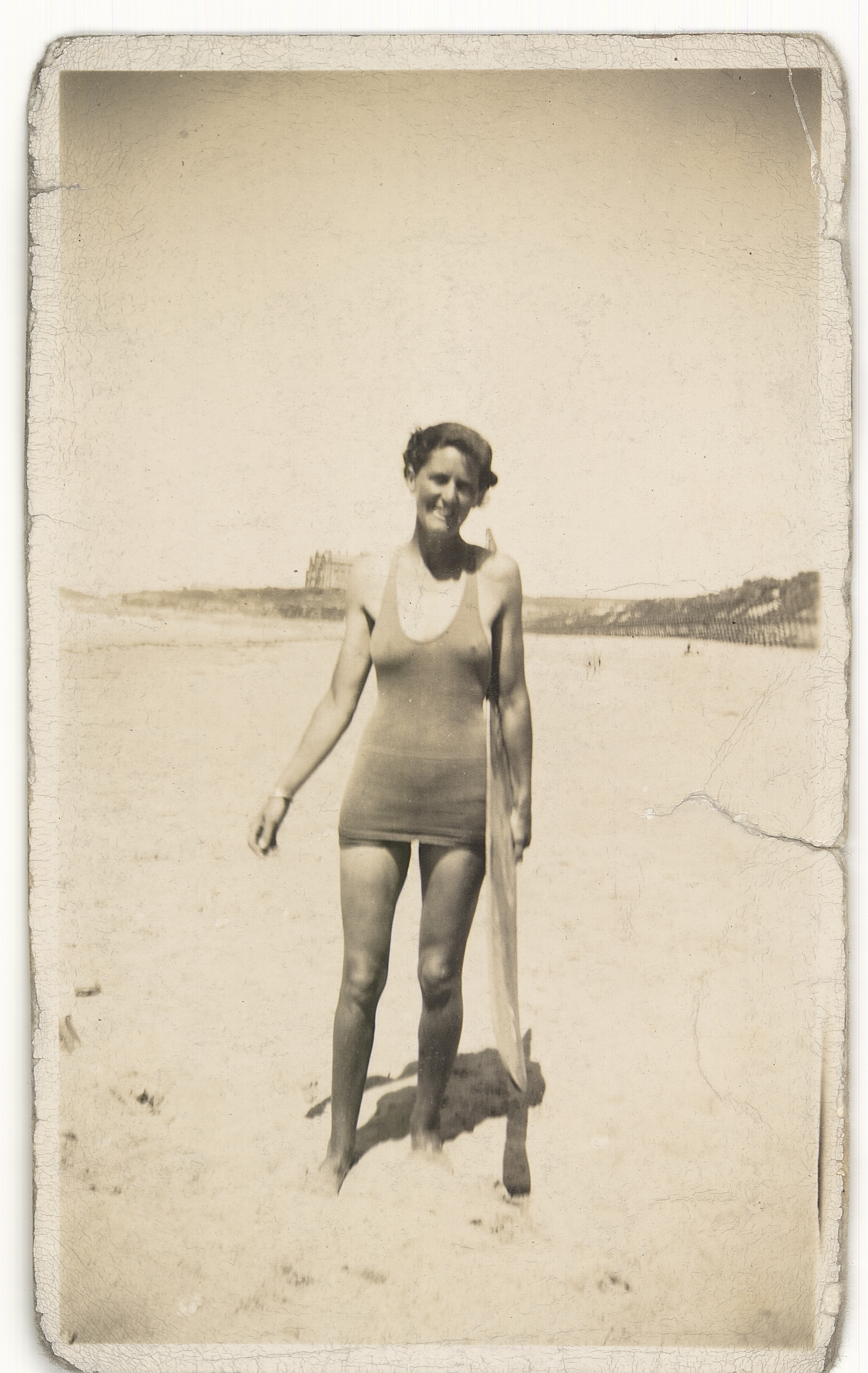 Woman in swimsuit standing on beach.