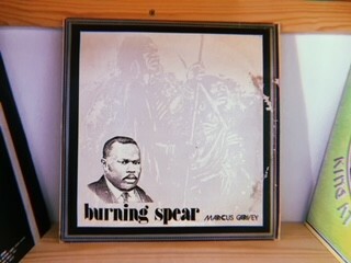 Framed black-and-white portrait of a man with the words "burning spear" printed below.