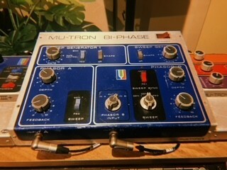 Blue electronic music mixing console with various knobs, buttons, and display screens.