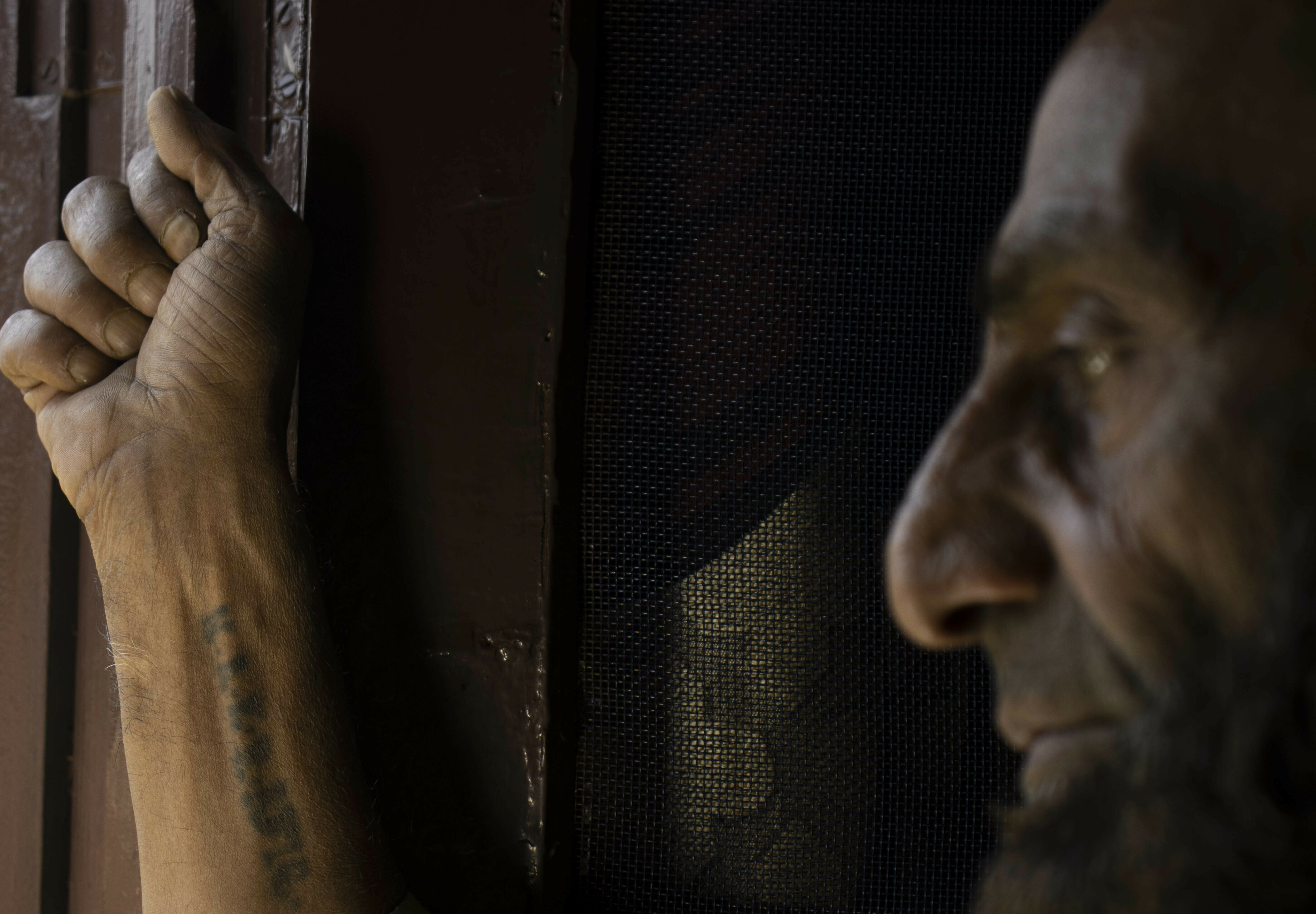 Close-up shot of a smiling man, his hands on his head in a joyous expression.