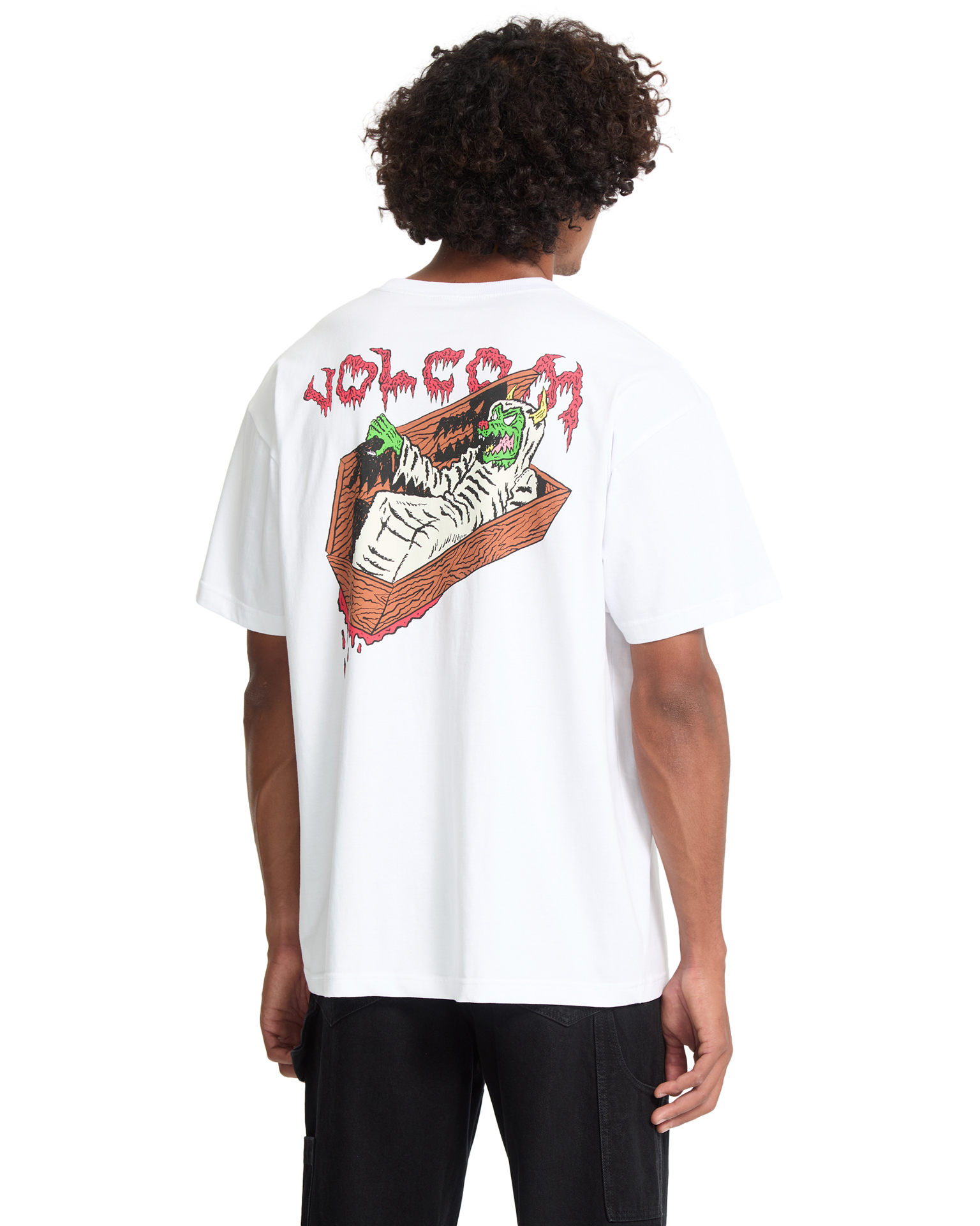 Back view of man wearing white t-shirt with graphic design featuring red text, brown coffin shape, and green skull illustration.