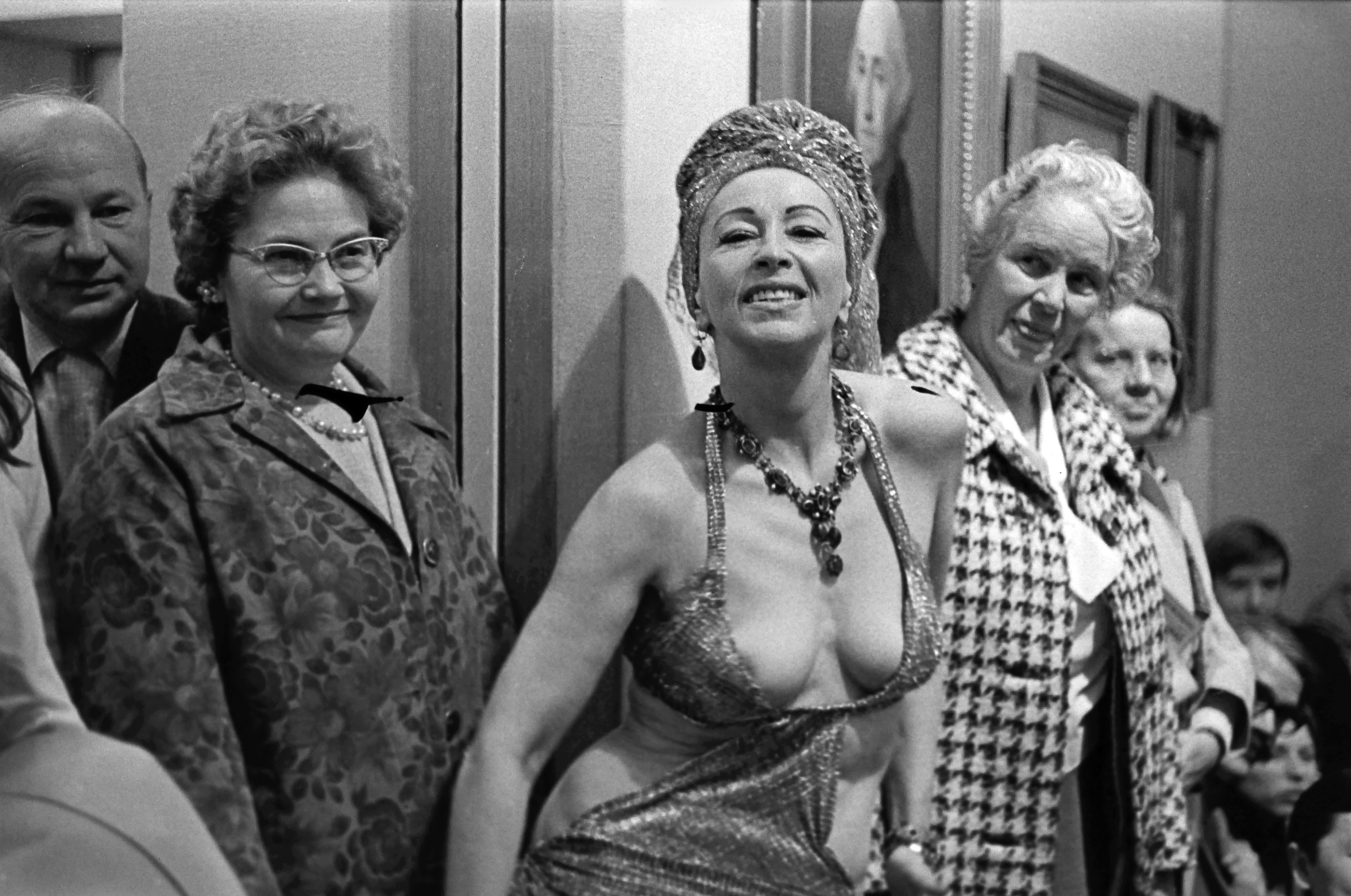 Four persons - three women and one man - posing outdoors. The women are wearing elaborate clothing and jewellery.