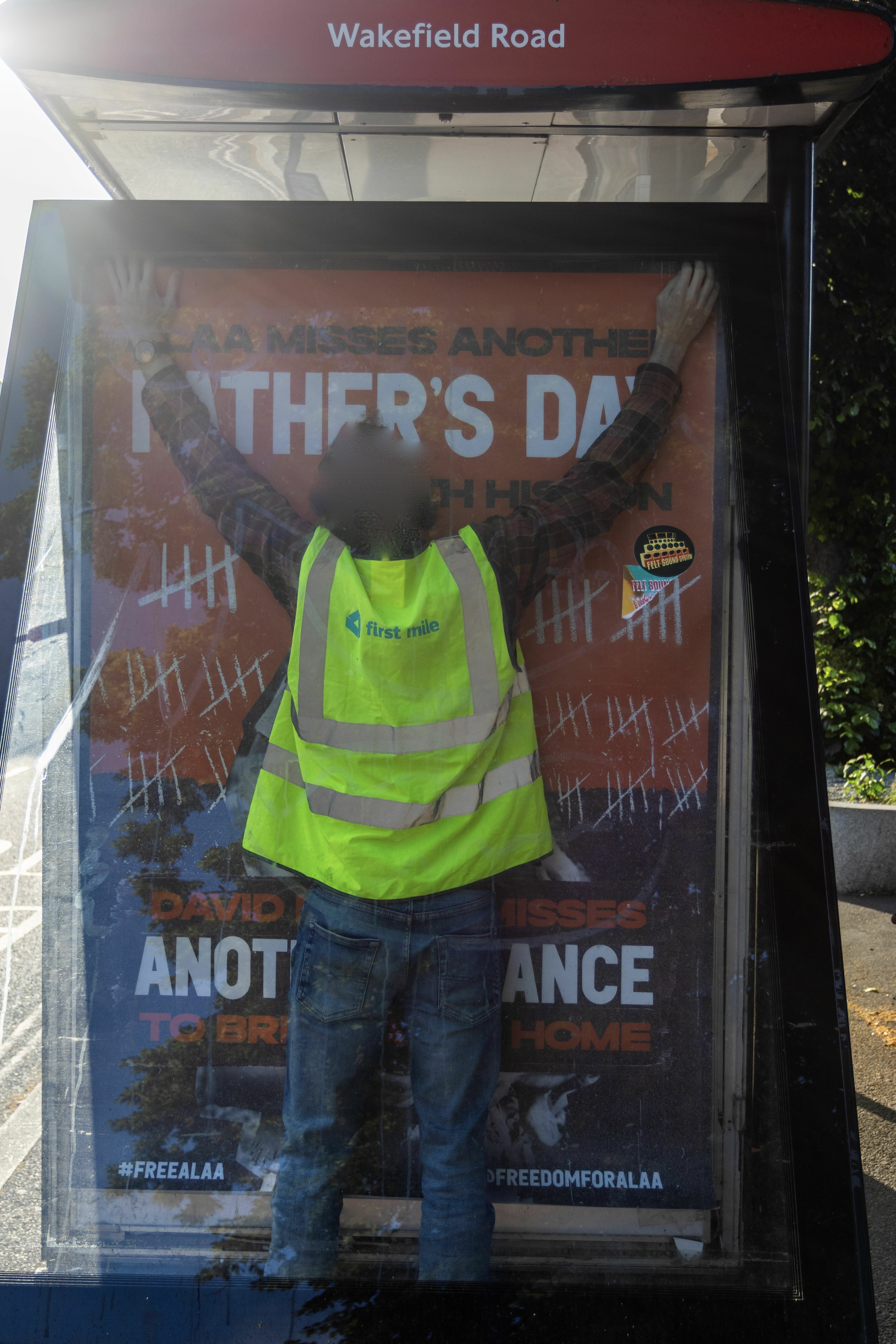 Bright fluorescent yellow high-visibility vest on display stand, with text "Father's Day" and "Another chance for peace" on the background.