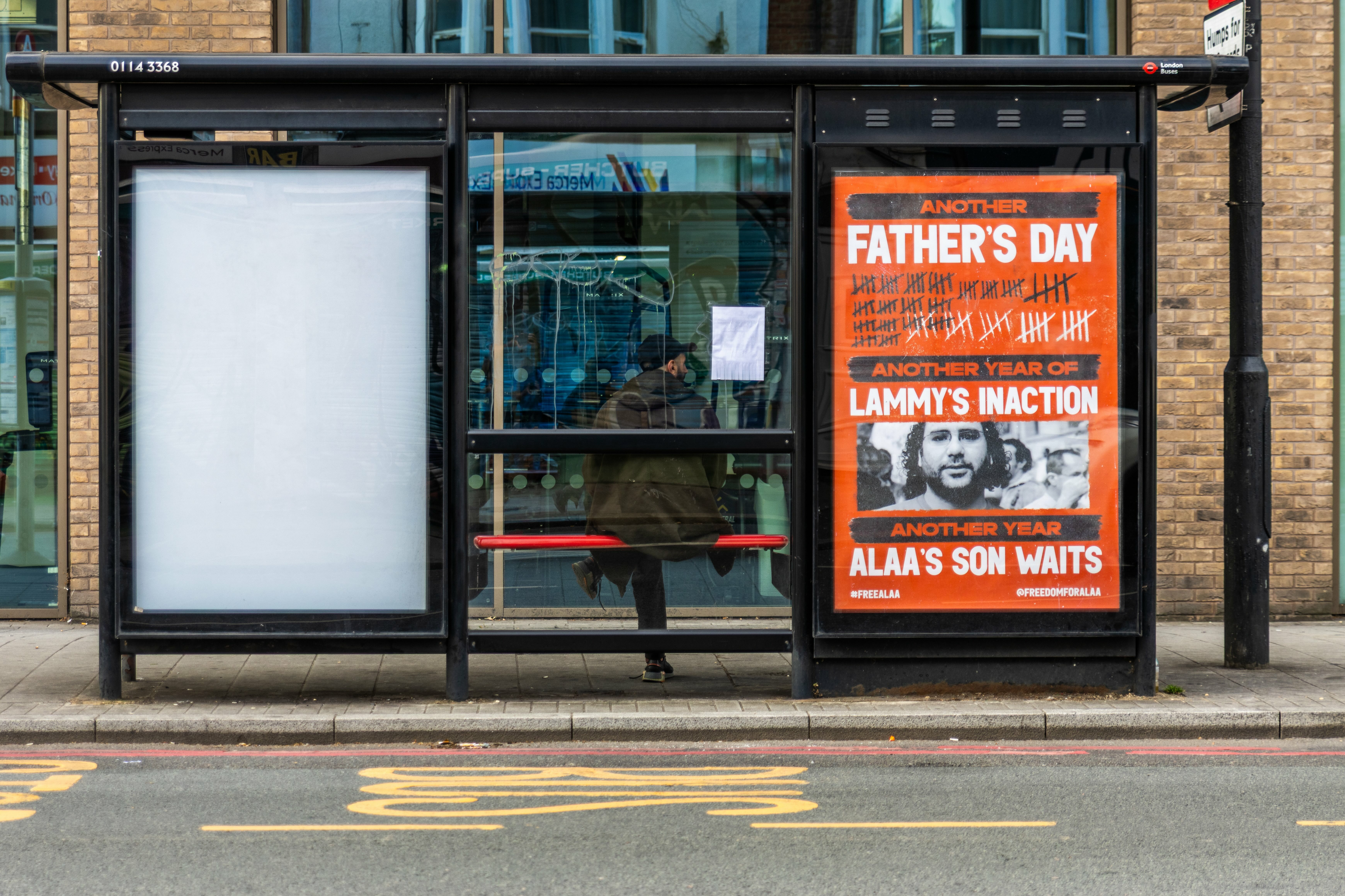 Bus shelter display advertising Father's Day with orange and black text against an image of a man's face.