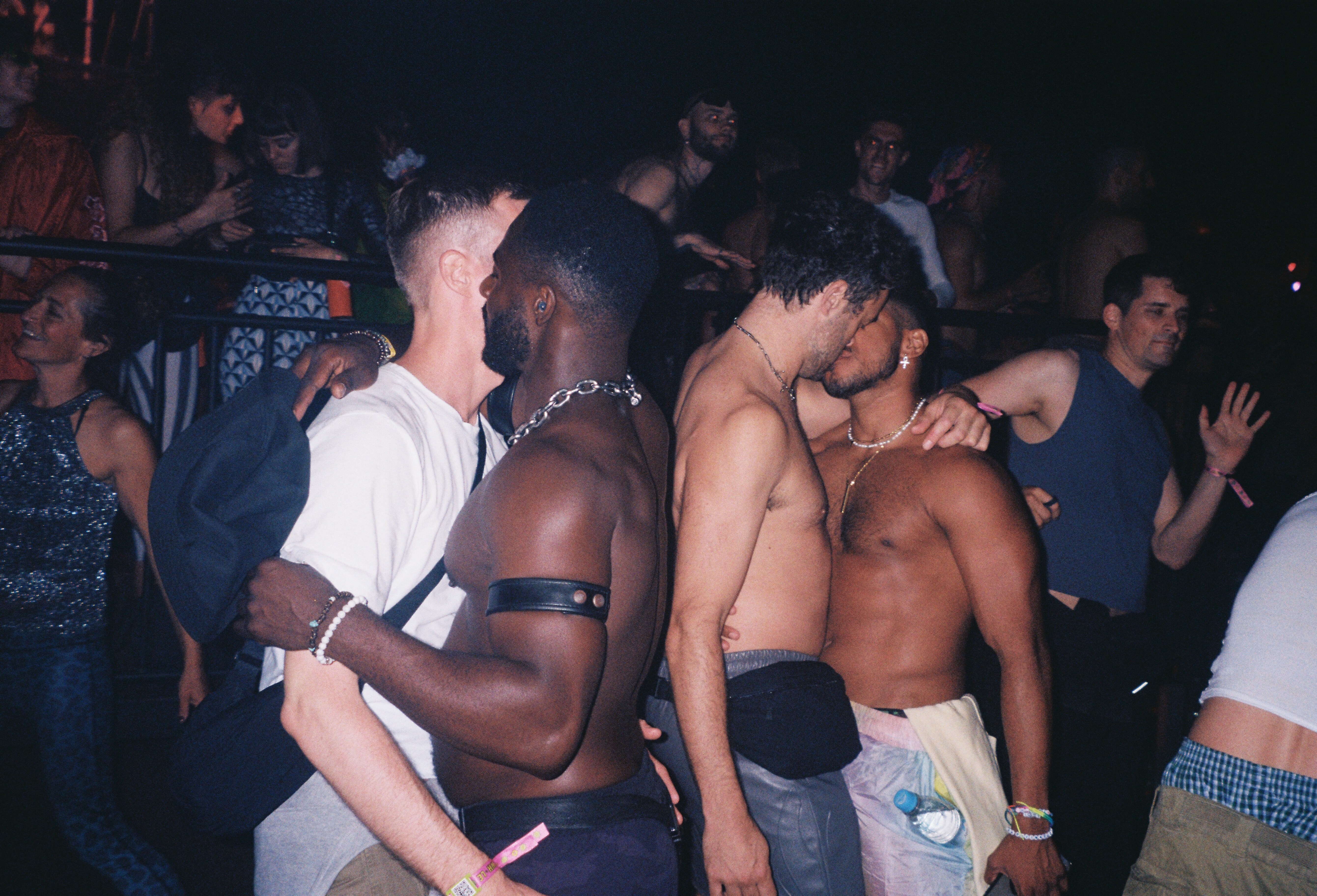A crowded dancefloor at a nightclub, with people dancing and interacting closely.