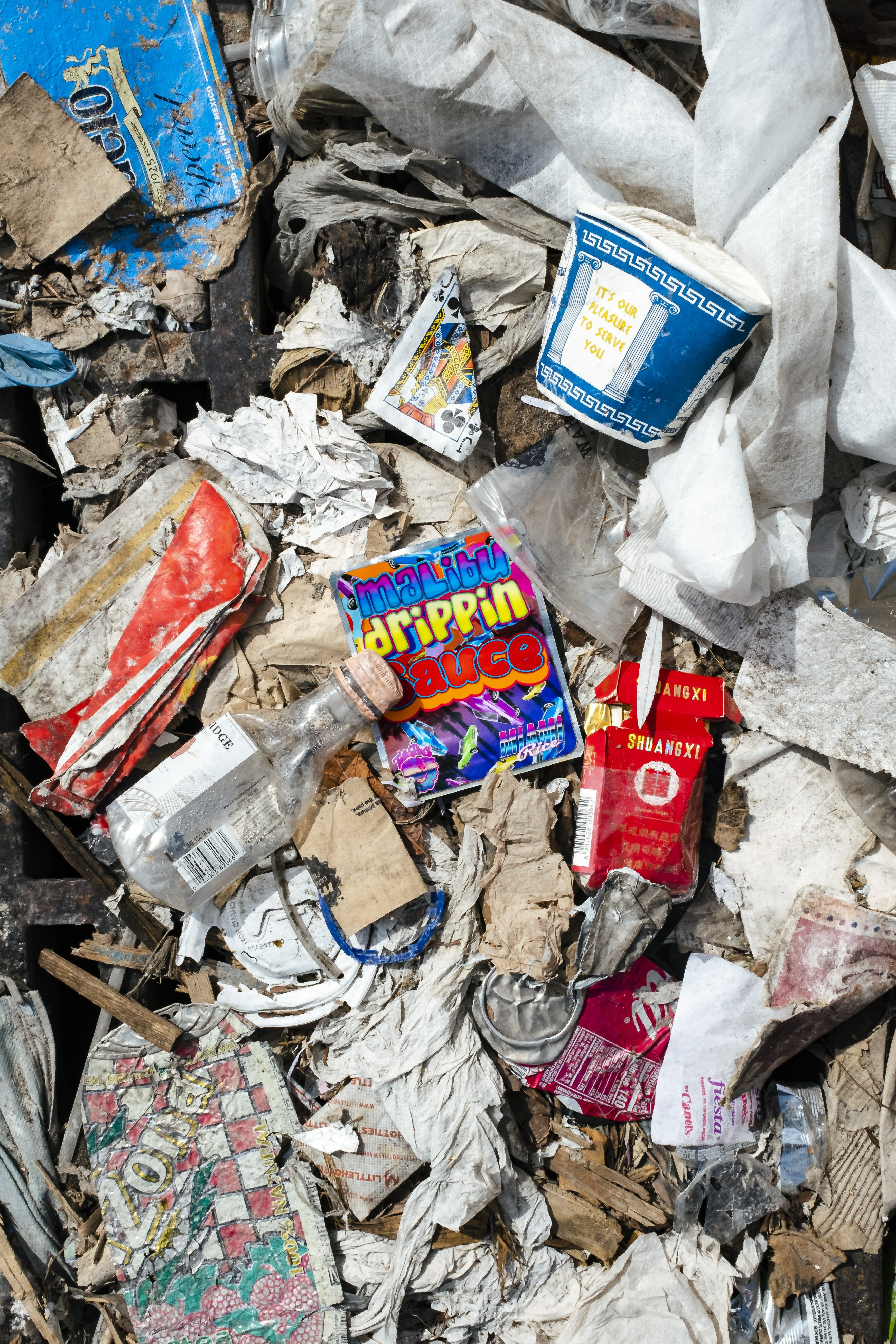 Discarded items, including food packaging, paper, and wires, scattered on the ground.