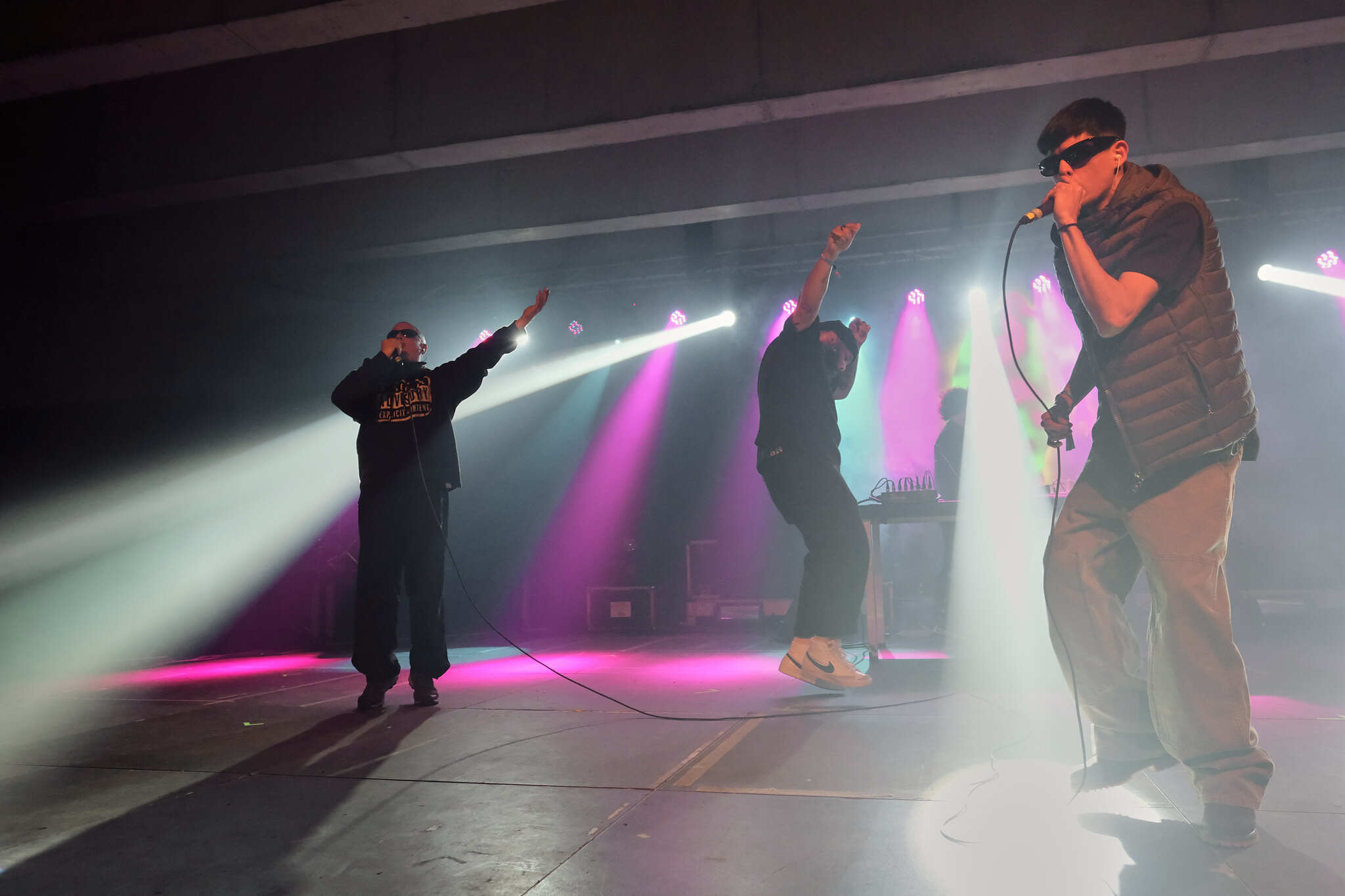 Four musicians performing on a dimly lit stage, with colourful spotlights illuminating the scene.