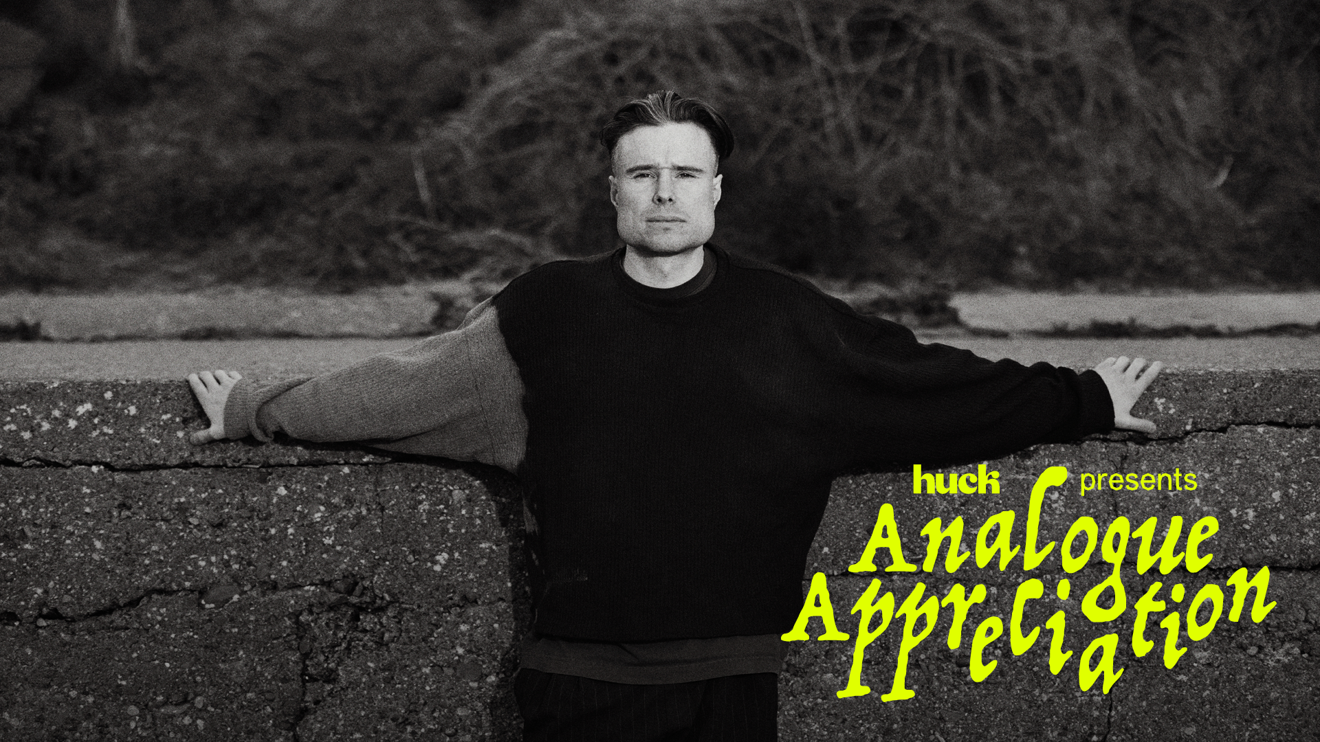 Black and white image of man in dark jumper with arms outstretched, yellow text overlay reading "hush presents Analogue Appreciation"