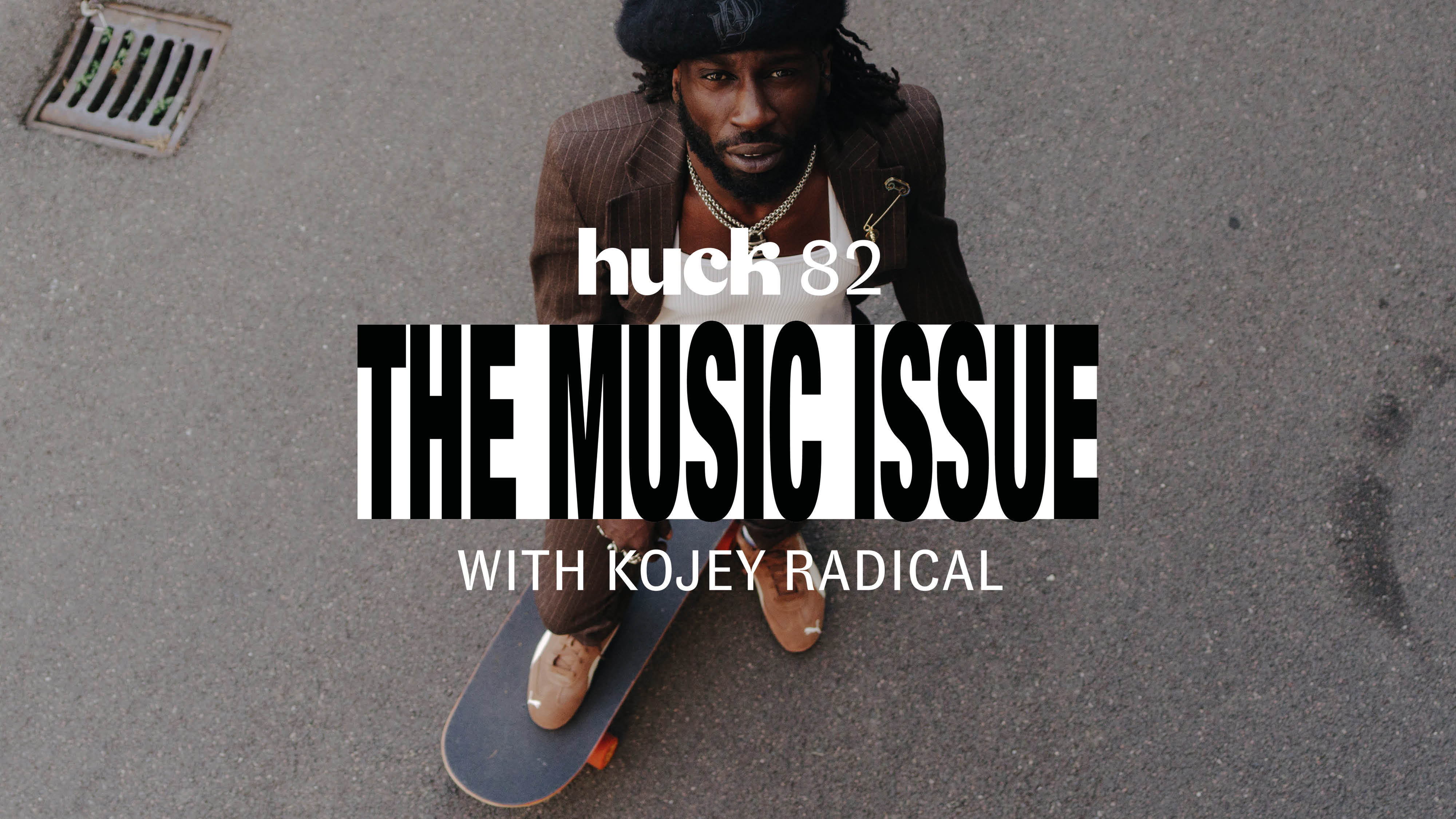 Man with dark hair sits on skateboard on grey pavement. White text overlay reads "huck 62 THE MUSIC ISSUE WITH KOJEY RADICAL".