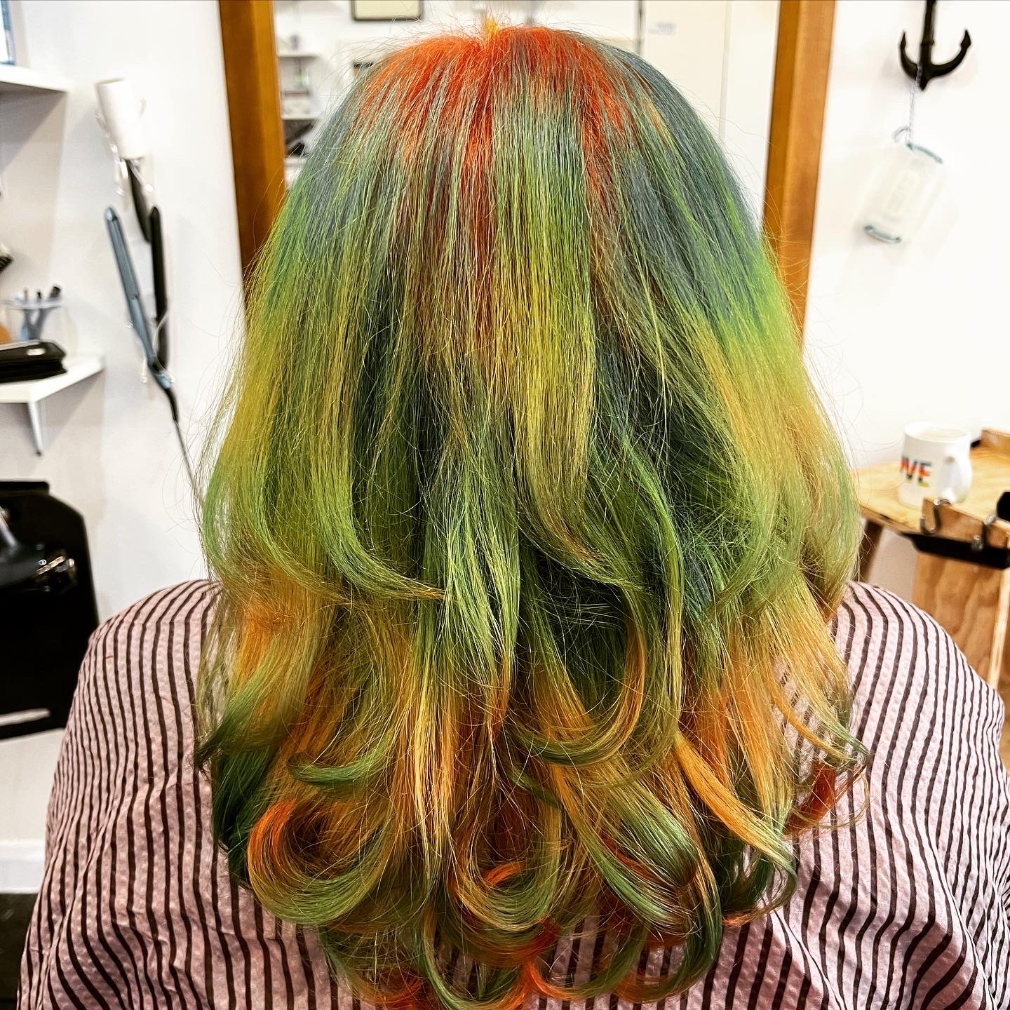 Colourful wavy hair in various shades of green, yellow, and orange.