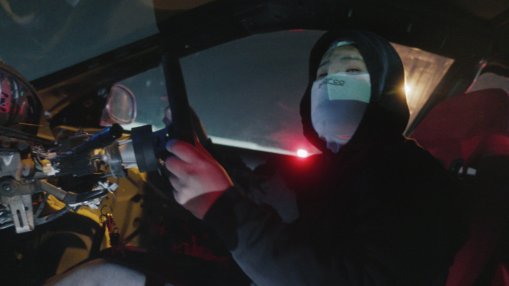 Dark spacecraft cockpit interior with curved viewing windows, control panels with glowing displays, and red warning light illumination.