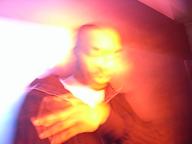 Blurred human figure in warm, vibrant colours of red, orange, and yellow.