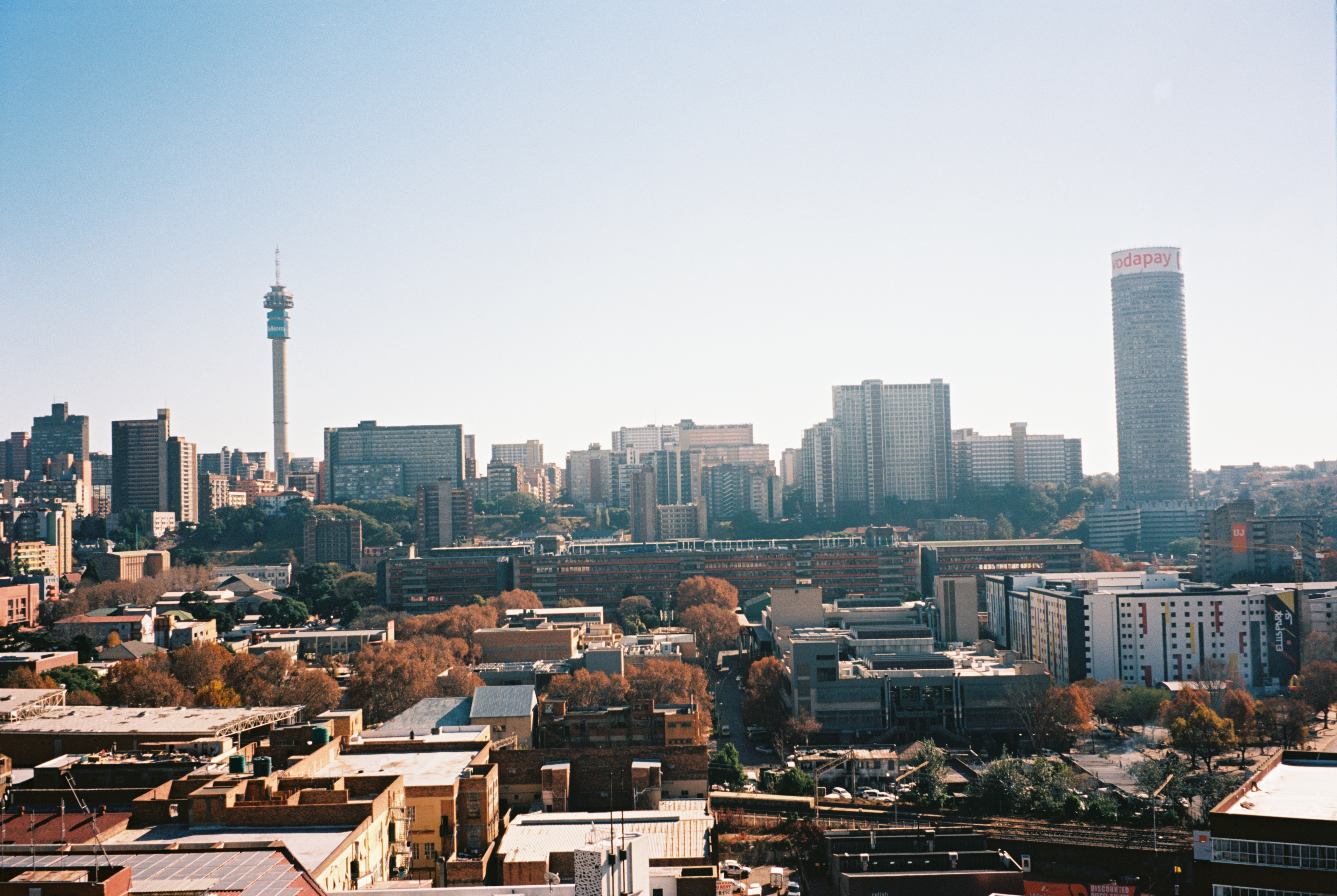 Towering skyscrapers, bustling streets, and cityscape extending to the horizon. A dense urban landscape with contrasting modern and older buildings.
